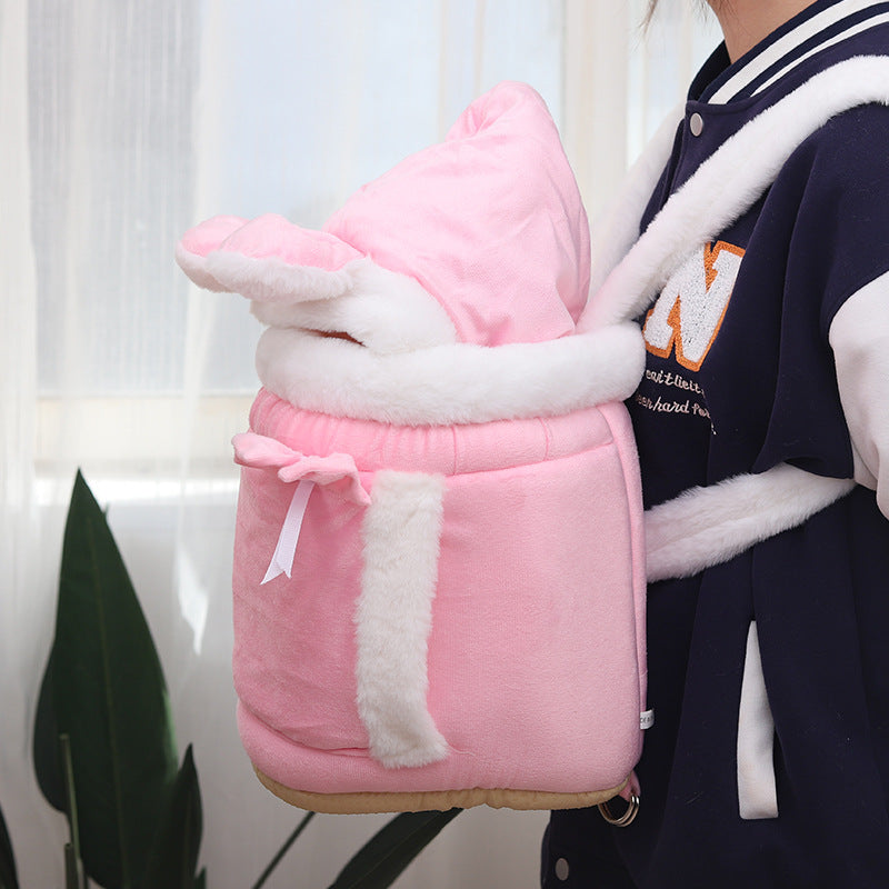 Person wearing a pink and white plush backpack with a hood.