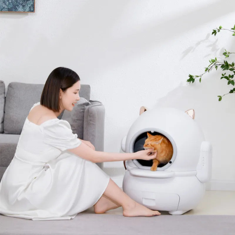 Woman interacting with a cat inside a modern white pet bed in a cozy living room.