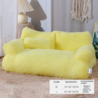 Yellow plush sofa in a room setting with a lamp and decorative items.
