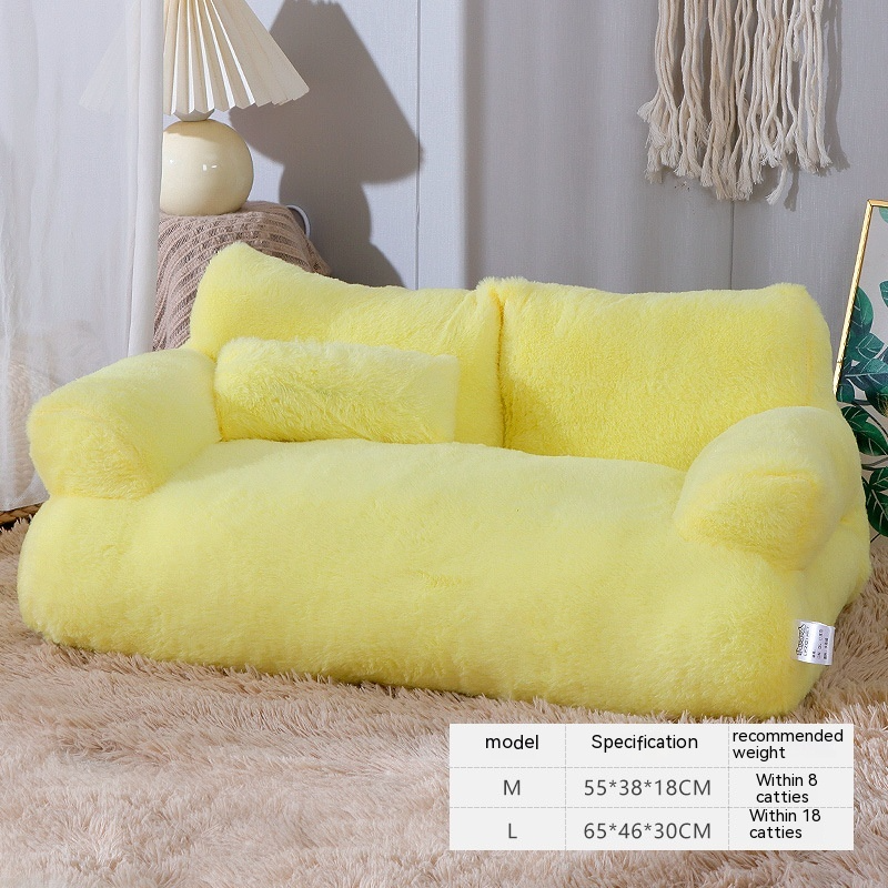 Yellow plush sofa in a room setting with a lamp and decorative items.