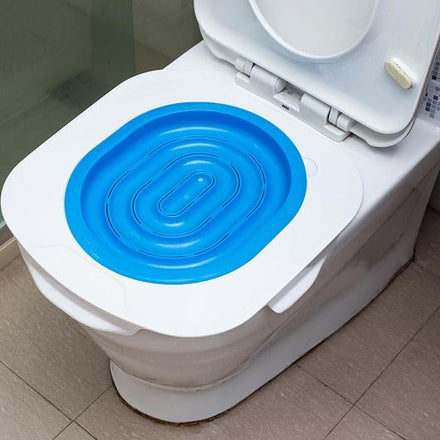 White toilet with a blue plastic seat cover on a tiled bathroom floor.