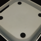 Close-up of a white electronic device with black components on a dark background