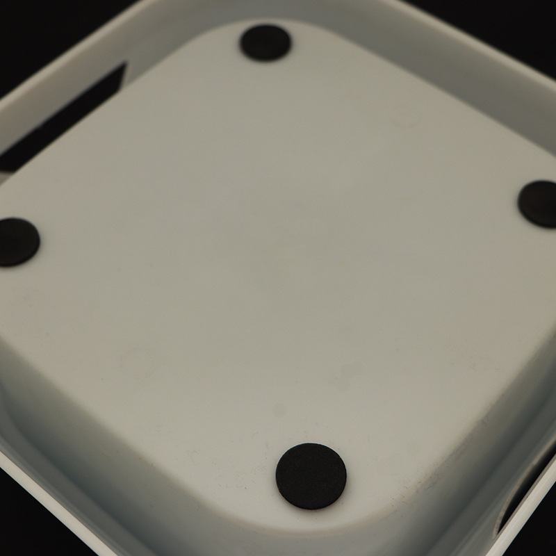 Close-up of a white electronic device with black components on a dark background