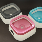 Three colorful pet bowls in gray, pink, and blue on a dark background