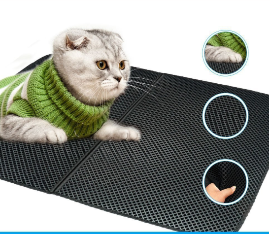 Cat wearing a green sweater on a black mat with circular insets showing details.