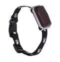 Black dog collar with paw prints and a rectangular electronic device on a white background
