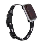 Black dog collar with paw prints and a rectangular electronic device on a white background