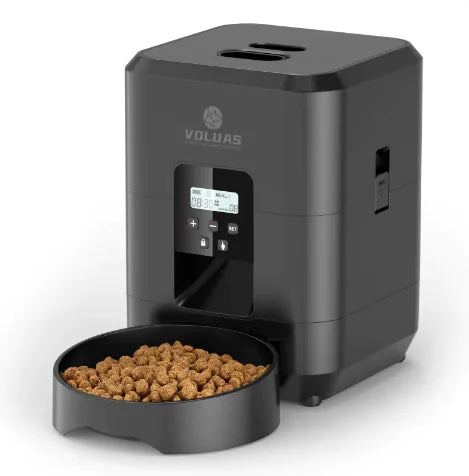 Black pet food dispenser with a bowl of kibble on a white background