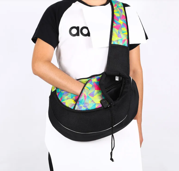 Person wearing a black sling bag with colorful geometric pattern on a white background