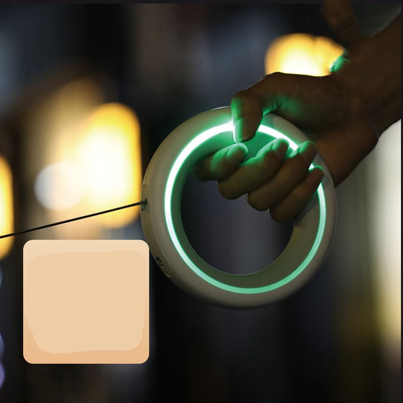 Hand holding a glowing green circular object with a blurred background