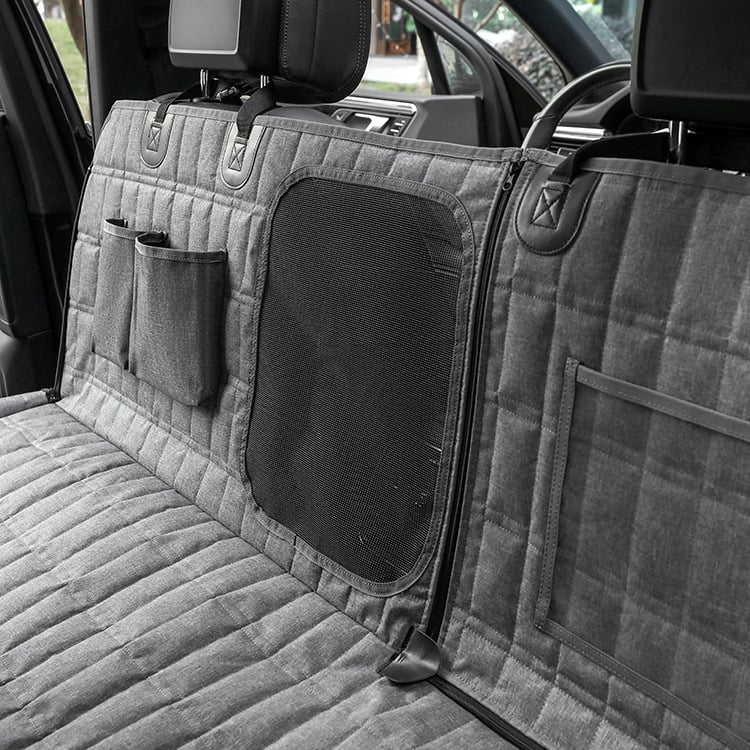 Gray car bench seat cover with storage pockets and a mesh panel in a vehicle.