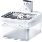 White pet water fountain with water flowing into a metal basin on a white background